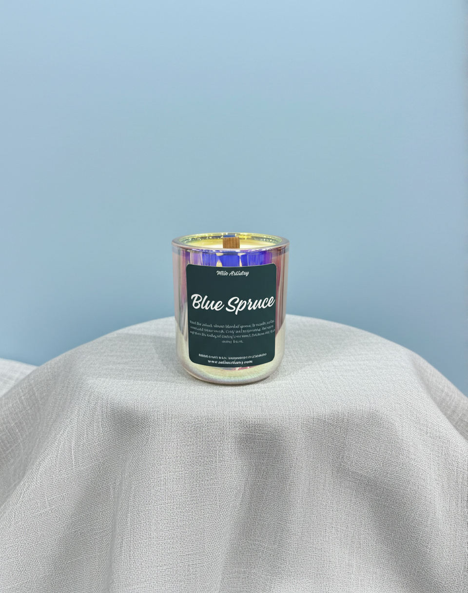 Candle labeled 'Blue Spruce' on a light gray surface with a light blue background