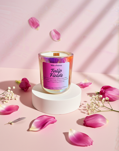 Candle labeled 'Tulip Fields' surrounded by pink petals on a soft pink background