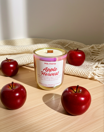 Candle labeled 'Apple Harvest' with red apples on a wooden surface