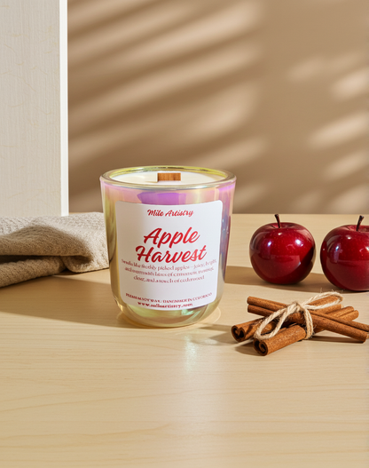 Apple Harvest candle with apples and cinnamon sticks on a wooden surface