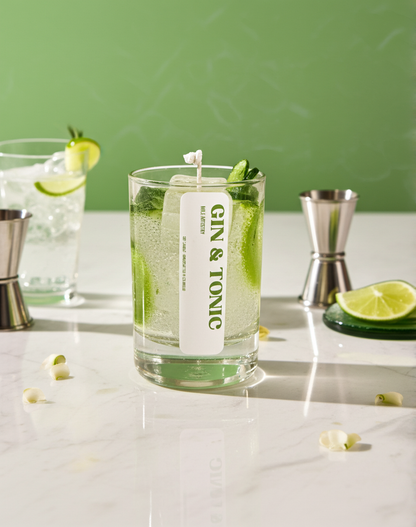 Gin & Tonic candle with lime slices and a green background