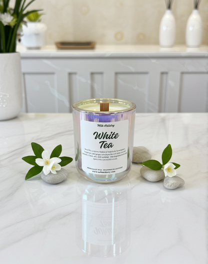 White tea candle with decorative elements on a white surface